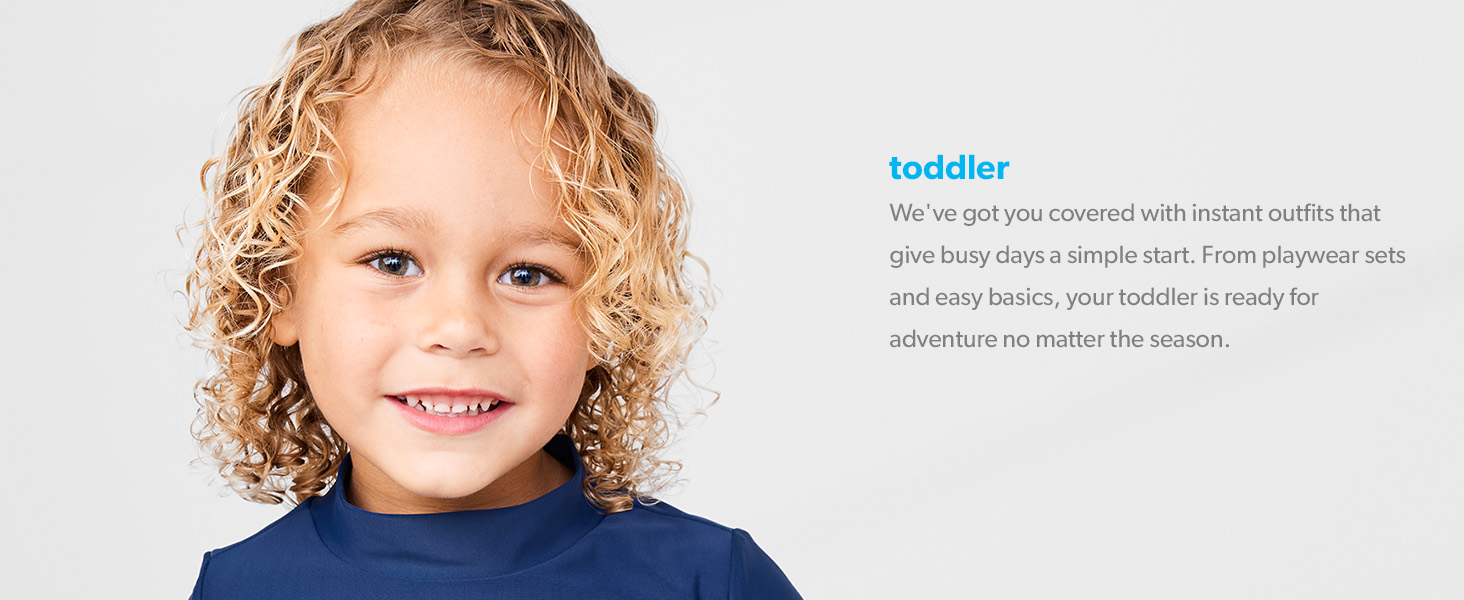 a toddler boy with blond curly hair in a navy swimsuit